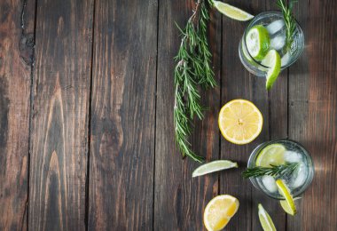 Alkollü içki cin tonik limon, biberiye ve rustik ahşap masa, kopya alanı buza kokteyl