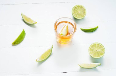 Altın tekila kireç dilimleri ve tuz üzerinde beyaz ahşap ba