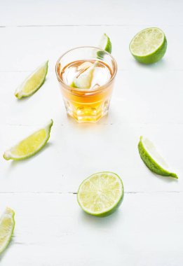 Altın tekila kireç dilimleri ve tuz üzerinde beyaz ahşap ba