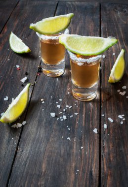 Limon dilimleri ve tuz ahşap backgrou üzerinde altın tekila