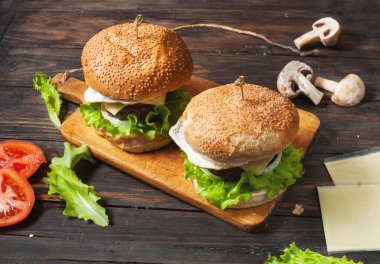 İki ev yapımı sığır eti hamburger ile ahşap masa üzerinde yumurta