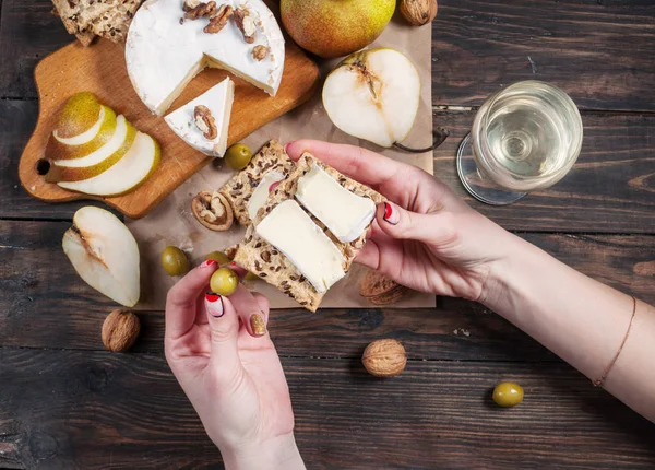 Жіночі руки забирають спокій з сиру і груші зі столу з їжею — стокове фото