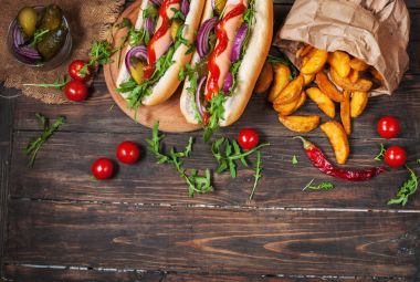 gemide sos ve sosisli patates kızartması ahşap bir masa üzerinde.