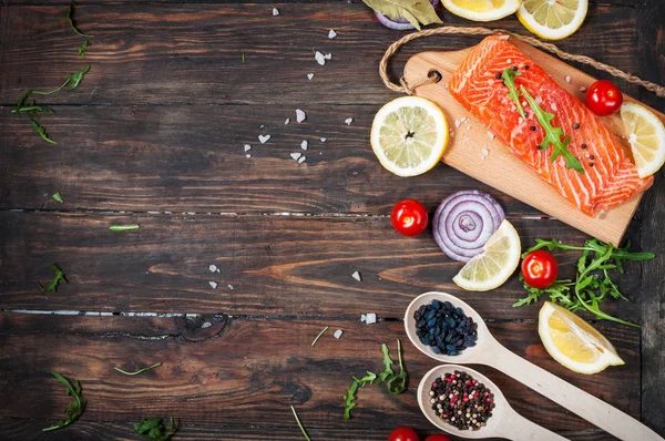 Heerlijke gedeelte van verse zalmfilet met aromatische kruiden, specerijen en groente - gezonde voeding, dieet of koken concept. Bovenaanzicht en copyspace — Stockfoto