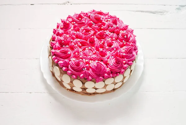 Cake with pink cream on white wood background. Pink cake