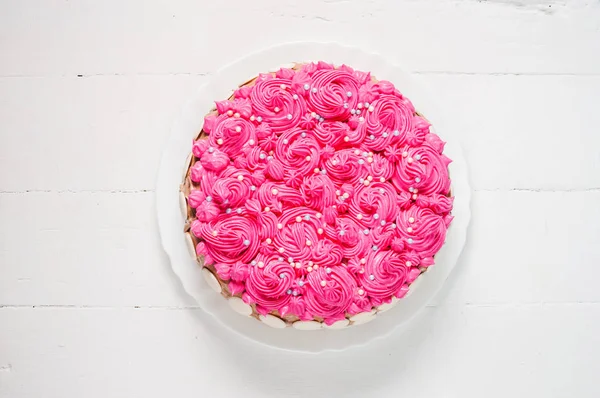 Beyaz ahşap zemin üzerinde pembe kremalı pasta. Pembe pasta.