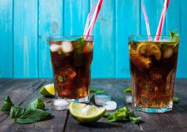 Ev yapımı Cuba Libre taze limon ile kahverengi ROM ve eski ahşap masa kırılmış buz