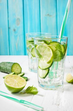 Detoks su soğuk ve ferahlatıcı limon, nane ve salatalık bir cam ahşap arka plan üzerinde infüzyon