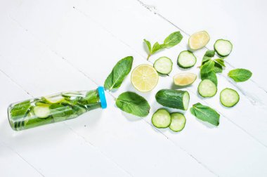 Soğuk ve ferahlatıcı limon, nane ve salatalık Beyaz ahşap zemin üzerinde bir şişede Detoks su infüzyon