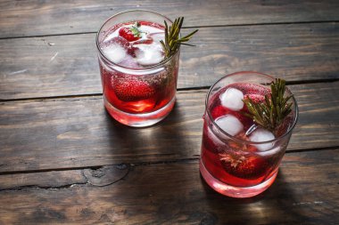 Kokteyl-mocktail. Meyveli kokteyl içki taze veya dondurulmuş ahududu, çilek, biberiye, buz ve soda ile dekore edilmiştir. Buz ve biberiye ile yerli kokteyl