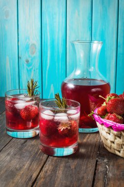 Kokteyl-mocktail. Meyveli kokteyl içki taze veya dondurulmuş ahududu, çilek, biberiye, buz ve soda ile dekore edilmiştir. Buz ve biberiye ile yerli kokteyl