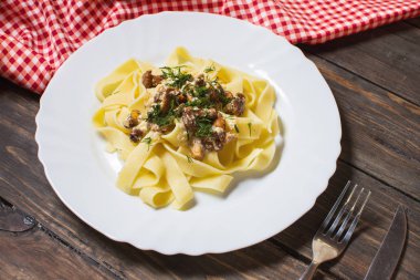 rustik ahşap masa üzerinde mantar soslu makarna