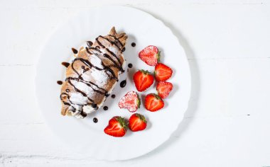 Lezzetli kahvaltı taze kruvasanlar ve Beyaz ahşap zemin üzerinde taze çilek ile