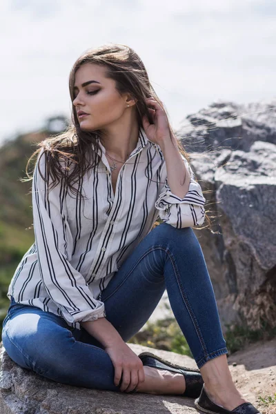 Una hembra caucásica con pelos largos está sentada en un parque. Una estudiante encantadora está descansando en el parque urbano —  Fotos de Stock