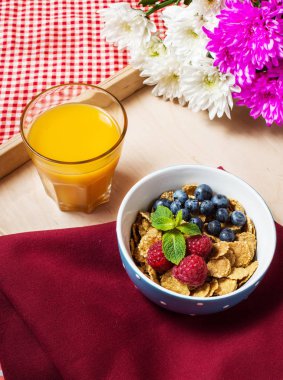 Tahıllı kepekli sağlıklı tahıl taze berry ve kahvaltıda meyve suyu bir bardak