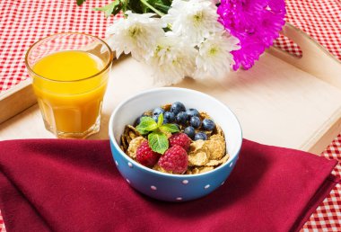 Tahıllı kepekli sağlıklı tahıl taze berry ve kahvaltıda meyve suyu bir bardak