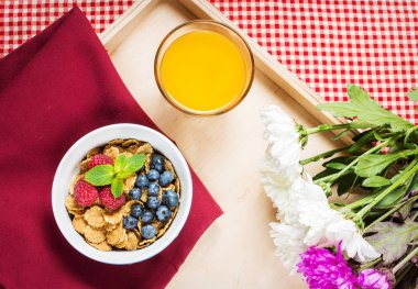 Tahıllı kepekli sağlıklı tahıl taze berry ve kahvaltıda meyve suyu bir bardak