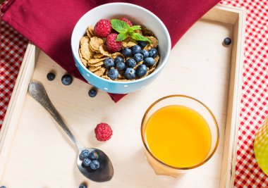 Tahıllı kepekli sağlıklı tahıl taze berry ve kahvaltıda meyve suyu bir bardak