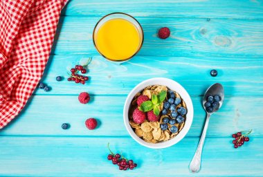 Tahıllı kepekli sağlıklı tahıl taze berry ve kahvaltıda meyve suyu bir bardak