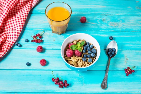 Multigrain wholewheat healthy cereals with fresh berry and a glass of juice for breakfast