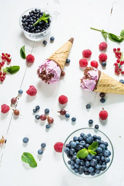 dondurma kaşık toz Beyaz ahşap zemin üzerinde taze çilek ile.