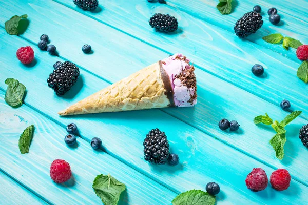 Kopeček zmrzliny s čerstvým ovocem na modrém pozadí. — Stock fotografie