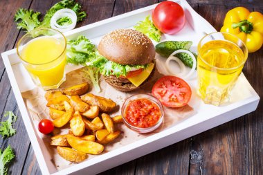 Taze ev yapımı hamburger, patates kızartması, bira ve suyu beyaz tepside servis