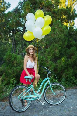 Bir bisiklet park şık genç kadın var. Bir gün Bisiklet keyfi kız