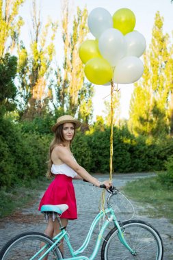 Bir bisiklet park şık genç kadın var. Bir gün Bisiklet keyfi kız