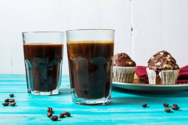 İki kahve ile kek ahşap masa üzerinde bir gözlük