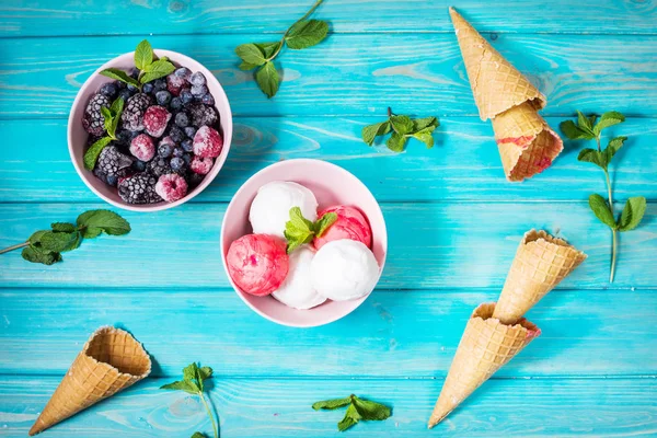 Kase, çilek ve gözleme koniler mavi ahşap masa üzerinde dondurma. Yaz