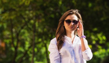 Kadın parkta dinleniyor. Kız güneş gözlüğü, açık yaz portre