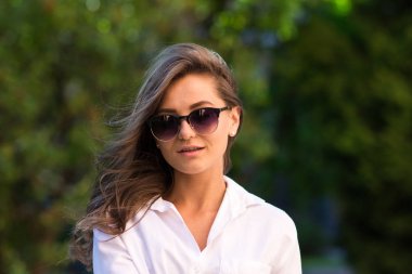 Kadın parkta dinleniyor. Kız güneş gözlüğü, açık yaz portre