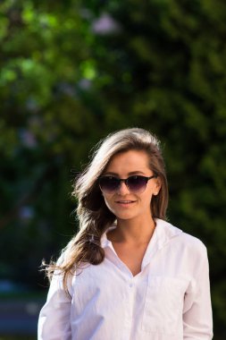 Kadın parkta dinleniyor. Kız güneş gözlüğü, açık yaz portre