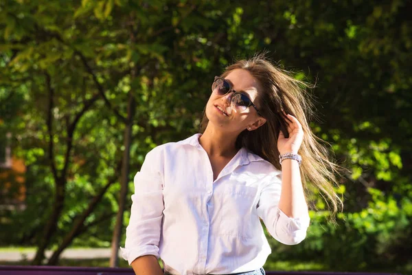 Kadın parkta dinleniyor. Kız güneş gözlüğü, açık yaz portre