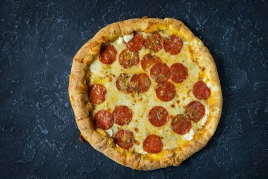 Rustik, vintage tarzı üzerinde biberli pizza. Karanlık taş masada Üstten Görünüm