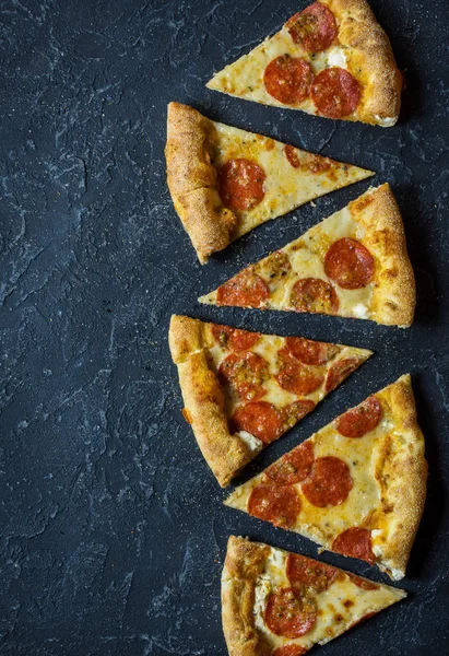 Rustik, vintage tarzı üzerinde biberli pizza. Karanlık taş tablo kopya alanı ile Üstten Görünüm