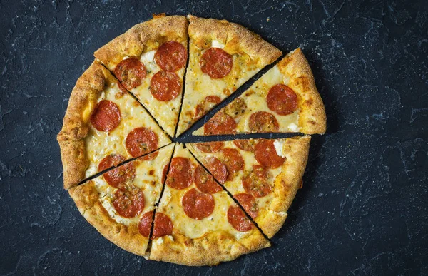 Rustik, vintage tarzı üzerinde biberli pizza. Karanlık taş masada Üstten Görünüm.