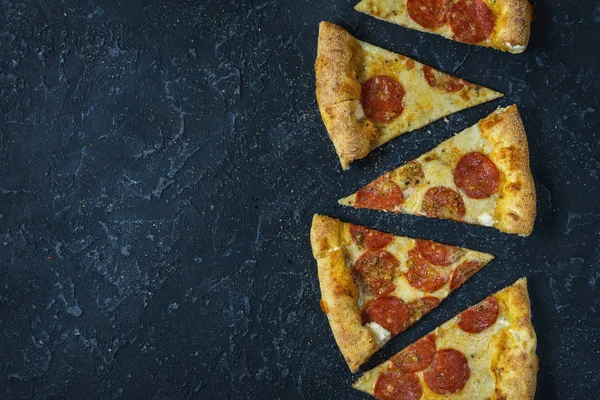 Rustik, vintage tarzı üzerinde biberli pizza. Karanlık taş tablo kopya alanı ile Üstten Görünüm