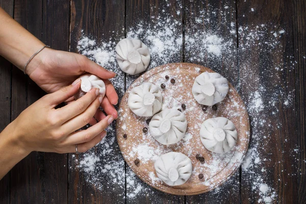 Cocina nacional georgiana Khinkali. La mujer prepara khinkali. Vista superior plato de masa de carne cruda sin cocinar. Proceso de cocción — Foto de Stock