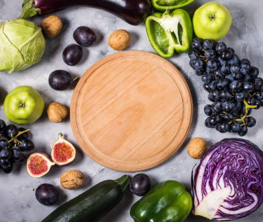 Taze organik çiğ yeşil ve mor renkli sebze ve meyve taş zemin üzerine. Üstten Görünüm. Boşaltmak.