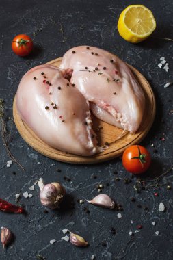 Taze çiğ tavuk fileto, baharatlar ve otlar siyah arka plan üzerine
