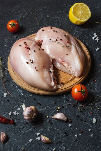 Taze çiğ tavuk fileto, baharatlar ve otlar siyah arka plan üzerine