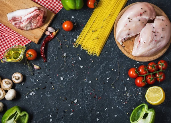 Pasta ingredientes. Pechugas de pollo, tomates cherry, pasta de espaguetis, tocino y champiñones en la mesa de piedra . — Foto de Stock