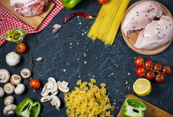 Makarna malzemeler. Tavuk göğsü, Cherry Domates, spagetti makarna, pastırma ve mantar taş masanın üzerinde. Üstten Görünüm