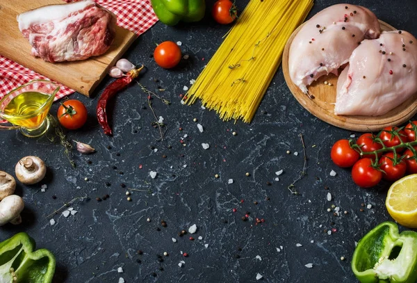 Pasta ingredientes. Pechugas de pollo, tomates cherry, pasta de espaguetis, tocino y champiñones en la mesa de piedra. espacio para texto . — Foto de Stock