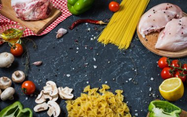 Makarna malzemeler. Tavuk göğsü, Cherry Domates, spagetti makarna, pastırma ve taş masanın üzerinde mantar.