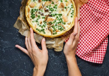 Karanlık taş zemin üzerine peynirli taze tavuk turtası. Fransız kiş. Ev yapımı tart. Eller.