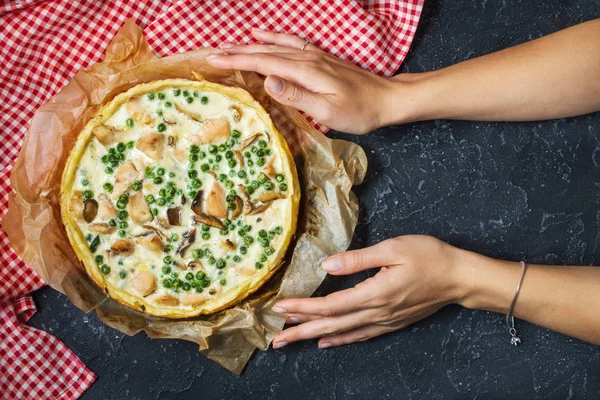 Karanlık taş zemin üzerine peynirli taze tavuk turtası. Fransız kiş. Ev yapımı tart. Eller.