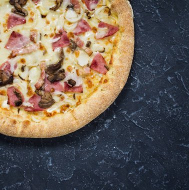 Pizza Carbonara siyah taş zemin üzerine. İtalyan Pizza Carbonara sosis, mantar ve peynir ile yakın çekim.